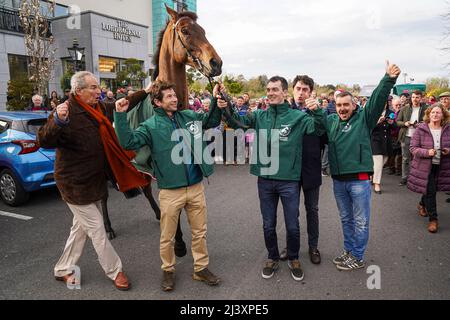 Le propriétaire gagnant Robert Waley-Cohen (à l'extrême gauche), le jockey Sam Waley-Cohen (deuxième à gauche), l'entraîneur Emmet Mullins (deuxième à droite) et le grand cheval gagnant national Noble Yeats posent pour des photos à l'extérieur de l'auberge Lord Bagenal lors de leur défilé de retour dans le comté de Carlow. Banque D'Images