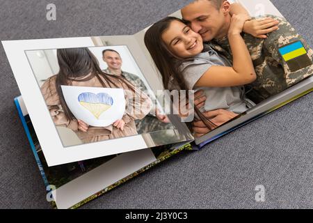 Archives photos de famille enregistrées dans un livre photo aux couleurs vives ; souvenirs d'été éclatants placés dans le livre photo. Famille avec drapeau de l'ukraine Banque D'Images