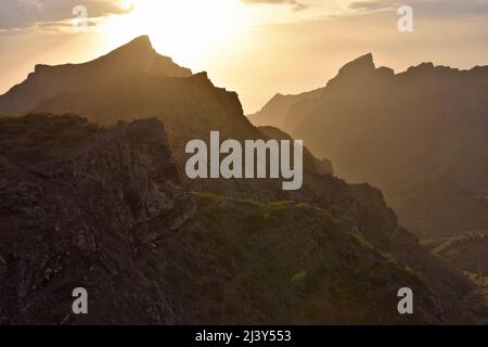 Soleil derrière les pics volcaniques de massif de Teno (Macizo de Teno) dans le nord-ouest de Tenerife Espagne. Banque D'Images