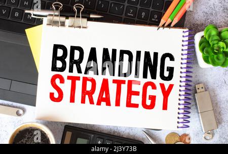 L'écriture de texte montrant la stratégie de marque. Concept d'affaires pour l'idée Marketing Plan rédigé sur sticky note papier, marqueur jaune fond de bois plié pap Banque D'Images