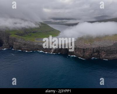 Belle vue aérienne cinématographique de la cascade de Bøsdalafossur et du lac Trælanípan - lagune magnifiques points de repère dans les îles Féroé Banque D'Images