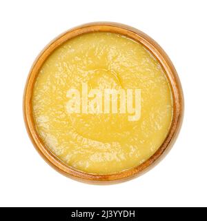 Sauce aux pommes dans un bol en bois. Compote de pommes transformée commercialement, sauce jaune faite de pommes pelées et cuites. Banque D'Images