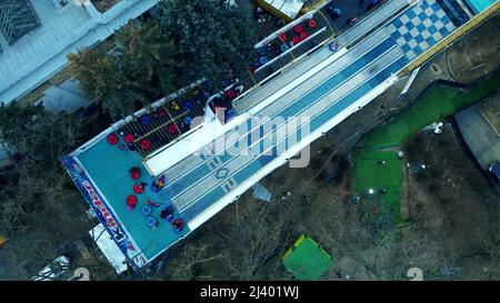 Les enfants descendent une colline de tubing de neige. Vue aérienne du Drone Banque D'Images