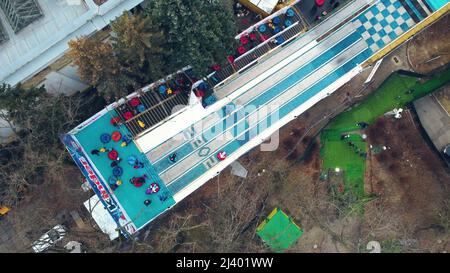 Les enfants descendent une colline de tubing de neige. Vue aérienne du Drone Banque D'Images