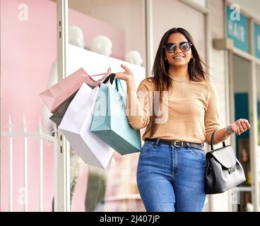 Qui n'aime pas un peu la thérapie de vente au détail. Portrait court d'une jeune femme attrayante portant un bouquet de sacs tout en faisant du shopping dans la ville. Banque D'Images