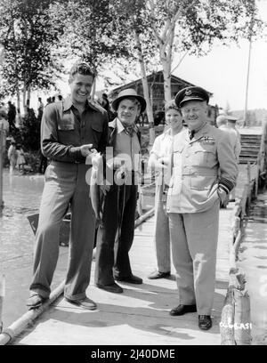 DENNIS MORGAN et JAMES CAGNEY avec les membres de l'équipe de cinéma sur place Candid en Ontario Canada pendant le tournage des CAPITAINES DES NUAGES 1942 réalisateur MICHAEL CURTIZ musique Max Steiner producteur associé William Cagney Warner Bros. Banque D'Images