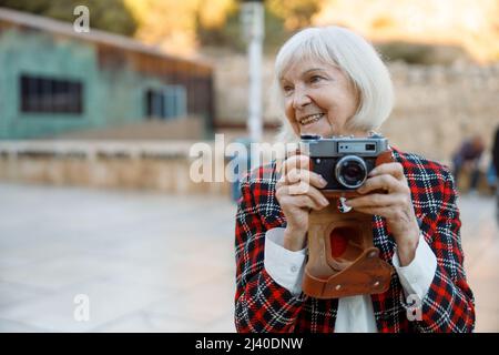 Femme âgée qui regarde loin en ville Banque D'Images