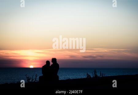 couple sur la mer au coucher du soleil Banque D'Images
