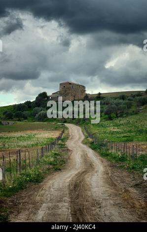 Ferme en Sicile paysage avec oliveraie, route de terre et ciel spectaculaire Banque D'Images