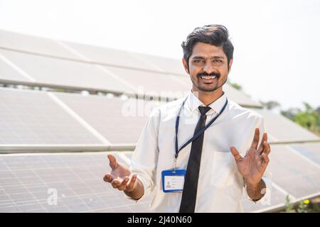 Ingénieur professionnel expliquant l'installation de panneaux solaires sur les terres agricoles en regardant la caméra - concprès de l'énergie renouvelable, écologique et Banque D'Images