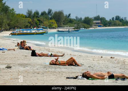 Les jeunes touristes occidentaux se détendent sur l'une des plages de Gili Trawangan. Banque D'Images