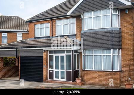 Une maison individuelle en brique avec garage et abri sur un nouveau bâtiment résidentiel à Cookridge, Leeds, Royaume-Uni. Banque D'Images