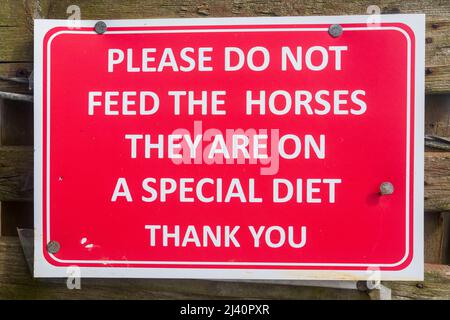 S'il vous plaît ne pas nourrir les chevaux ils sont sur Un régime spécial - un panneau d'information de visiteur sur une barrière de paddock pour empêcher les randonneurs nourrissant les chevaux et l'empoisonnement. Banque D'Images