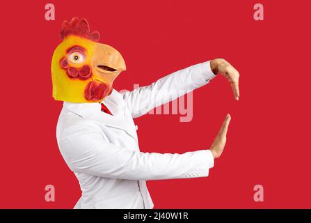Homme portant un étrange drôle de masque de poulet dansant et ayant l'amusement à la fête d'animal fou Banque D'Images