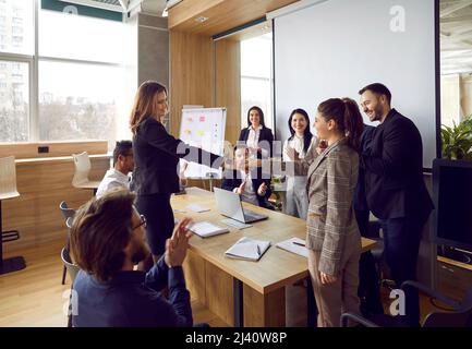 Deux équipes d'affaires heureuses se réunissent au bureau, faisant une affaire et échangeant des poignées de main Banque D'Images