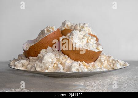 Poudre de protéine d'œuf sur une assiette et des coquilles d'œuf. Nutrition sportive. Banque D'Images