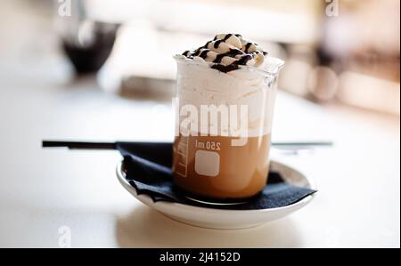 Délicieux café avec crème fouettée dans un verre Banque D'Images