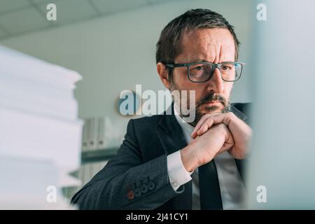 Homme d'affaires en difficulté regardant l'écran d'ordinateur portable dans le bureau d'affaires, attention sélective Banque D'Images