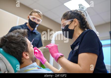 Patient ayant un examen dentaire lors d'une consultation dentaire Banque D'Images