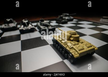 Tanks de jouets sur un échiquier. Le concept de stratégie militaire. Banque D'Images