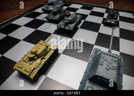 Tanks de jouets sur un échiquier. Le concept de stratégie militaire. Banque D'Images