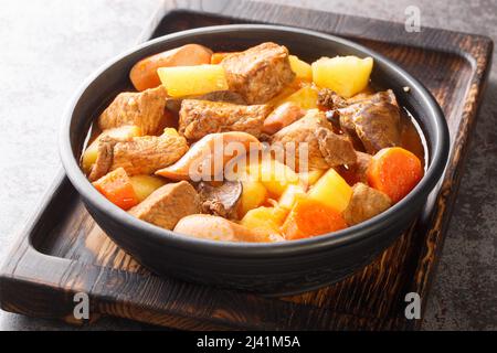 Savoureux porc Menudo est un plat de ragoût philippin qui est typiquement fait avec le porc, le foie, les tomates, les pommes de terre, et d'autres légumes dans l'assiette sur t Banque D'Images