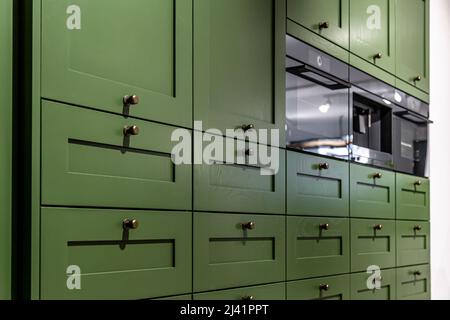 Grande armoire de cuisine verte avec de nombreuses poignées, gros plan. Banque D'Images