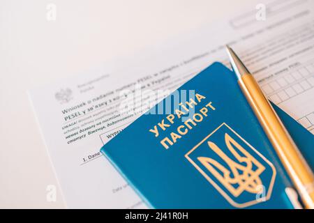 Document PESEL, passeport ukrainien et stylo sur fond de table blanc. Banque D'Images