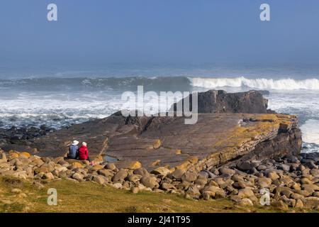 Regarder les vagues de la Breaking Rock de Greymaare sur la plage d'Embleton, près de Dunstanburgh, Northumberland, Angleterre Banque D'Images