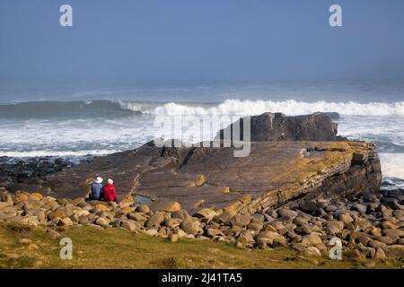 Regarder les vagues de la Breaking Rock de Greymaare sur la plage d'Embleton, près de Dunstanburgh, Northumberland, Angleterre Banque D'Images