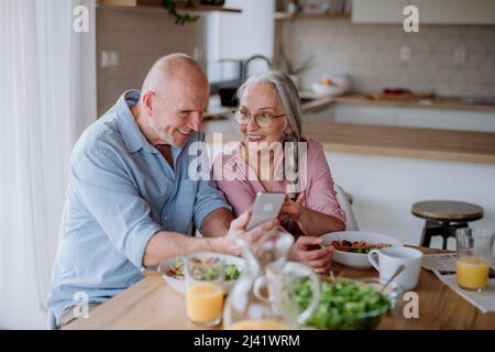 Un couple senior heureux dînant ensemble à la maison. Banque D'Images