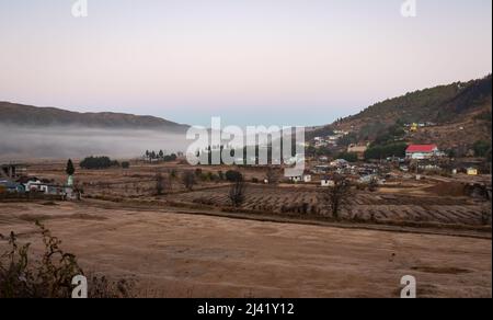 petit village aux contreforts de montagne couvert de brume blanche et ciel spectaculaire au lever du soleil image est prise à nongnah meghalaya inde. Banque D'Images