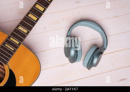 vue depuis le dessus de la guitare et des écouteurs verts sur fond de bois, gros plan Banque D'Images