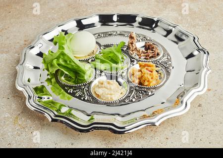 Assiette de Pâque Seder avec cuisine traditionnelle ontravertin fond de pierre Banque D'Images