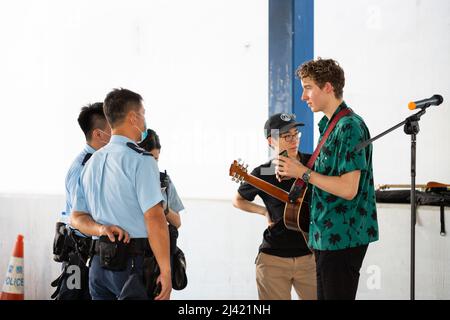 20 6 2020 policiers avec masque facial vérifient des documents d'artistes de musique de rue de jeunes musiciens caucasiens et chinois dans le Centre, Hong K Banque D'Images
