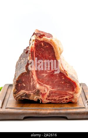 Viande de bœuf de porc ou de T-bone cru vieilli à sec Steak avec tomates et poivrons. Fond blanc. Iakın çekim Banque D'Images