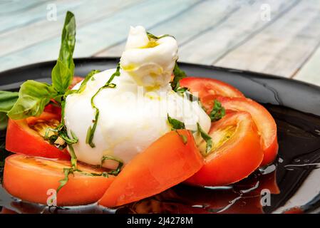 Le burrata est un fromage de lait de vache frais, fait de pâtes filata et de forme ronde, avec une apparence externe semblable à celle de mozzarella dans la forme Banque D'Images