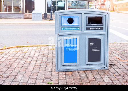 Bac de recyclage sur un trottoir en briques dans un centre-ville Banque D'Images