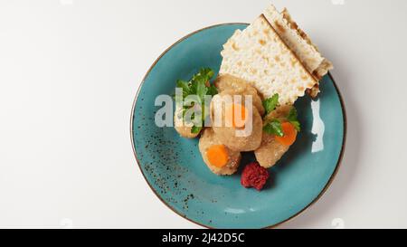 Poisson Gefilte avec carotte. Assiette de poisson gefilte traditionnel de Pessah sur table Banque D'Images