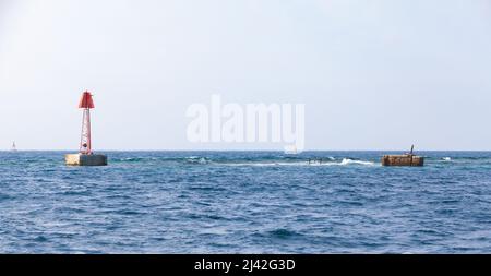 La tour de balise rouge se trouve sur le bord d'un fairway, structure encadrée avec une marque supérieure triangulaire. Golfe persique, Arabie Saoudite Banque D'Images