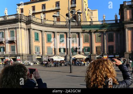 Naples, Italie - 3 janvier 2020. Vue arrière de deux femmes prenant des photos avec leur smartphone dans les bâtiments de Piazza Colombo, dans le centre historique Banque D'Images