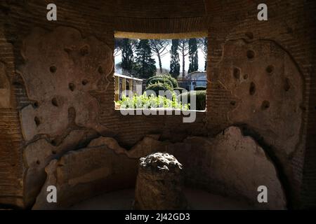 Pompéi. Italie. 5 janvier 2020. Vue sur un jardin depuis une fenêtre dans le mur en pierre d'une ancienne maison de Pompéi. C'était une ancienne ville romaine dans la sout Banque D'Images