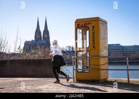 Une ancienne boîte téléphonique se trouve sur les rives du Rhin dans le quartier Deutz, vue sur la cathédrale, Cologne, Allemagne. Eine alte Telefonzelle stht am Banque D'Images