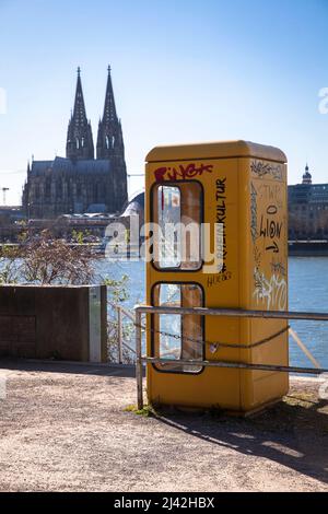 Une ancienne boîte téléphonique se trouve sur les rives du Rhin dans le quartier Deutz, vue sur la cathédrale, Cologne, Allemagne. Eine alte Telefonzelle stht am Banque D'Images