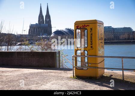 Une ancienne boîte téléphonique se trouve sur les rives du Rhin dans le quartier Deutz, vue sur la cathédrale, Cologne, Allemagne. Eine alte Telefonzelle stht am Banque D'Images