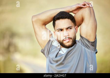 Allez-vous faire des progrès ou des excuses ? Photo d'un jeune homme sportif qui étire les bras tout en s'exerçant à l'extérieur. Banque D'Images