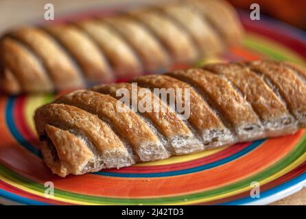 Deux petits pains à saucisse sur une assiette colorée. Banque D'Images
