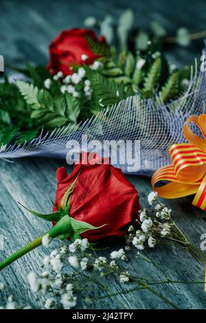 gros plan d'un bouquet avec une rose rouge attaché avec un ruban à motifs avec le drapeau catalan pour Sant Jordi, Saint George Day, quand il est tradition de donner Banque D'Images