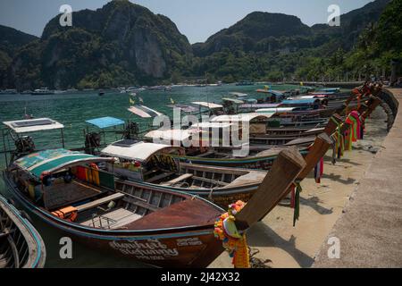 Krabi, Thaïlande. 9th avril 2022. Une rangée de bateaux à longue queue attendant sur la plage de sable de l'île de Phi Phi Don. Connue depuis longtemps comme une destination de voyage internationale populaire, la Thaïlande a subi des dommages massifs à son industrie touristique en raison des restrictions de voyage imposées par la pandémie. Le Krabi, une province célèbre pour ses falaises calcaires déchiquetées, a été pratiquement déserté pendant la plus grande partie de 2020 et 2022. L'assouplissement des restrictions d'entrée par le gouvernement thaïlandais a encouragé les visiteurs à commencer à revenir. (Credit image: © Adryel Talamantes/ZUMA Press Wire) Banque D'Images