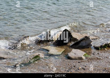 Vagues de mer se brisant doucement sur des rochers sur la plage à Swanage, Dorset, Angleterre Banque D'Images